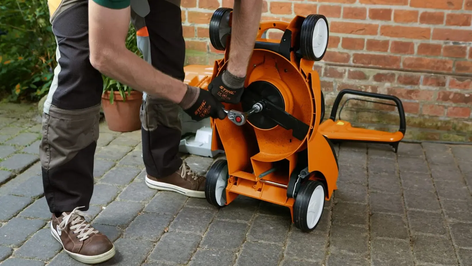 A technician sharpening reel mower blades in a workshop