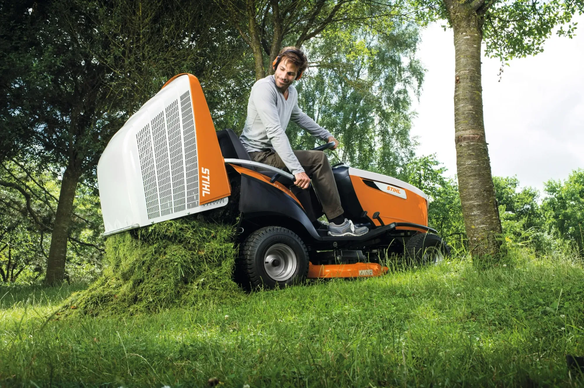 Ride-on mower and push mower side by side on a Kiwi lawn